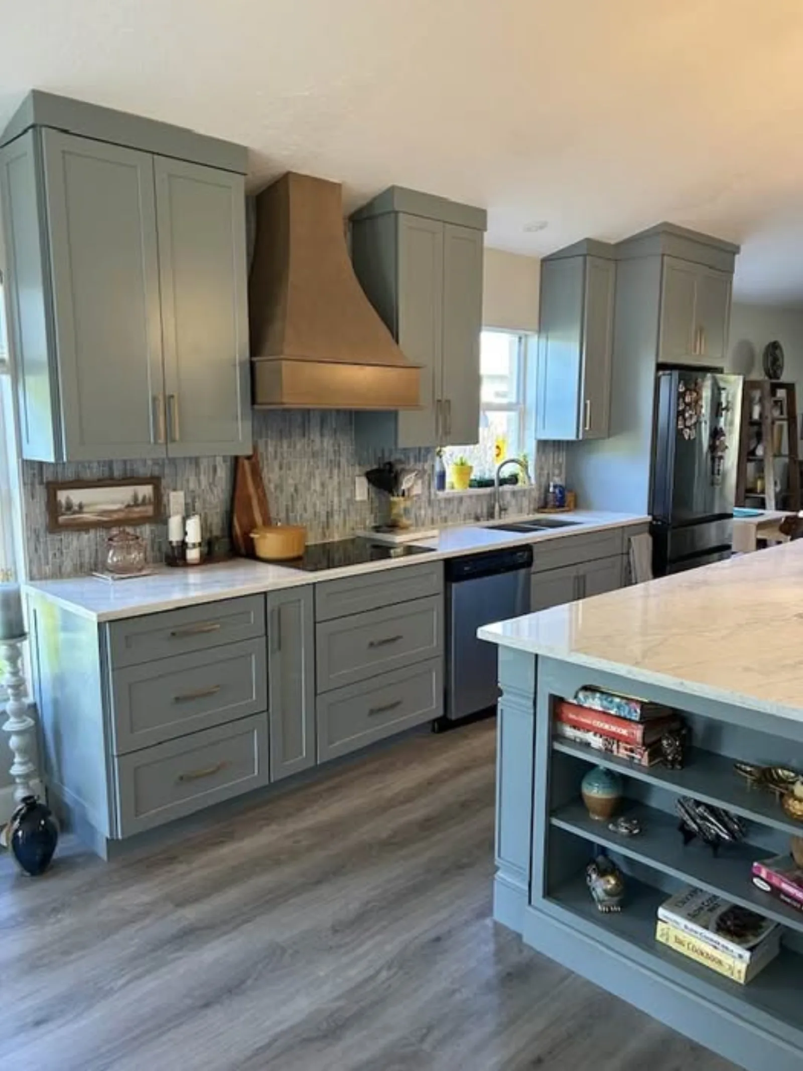 Sage green shaker kitchen with custom wood range hood and quartz island