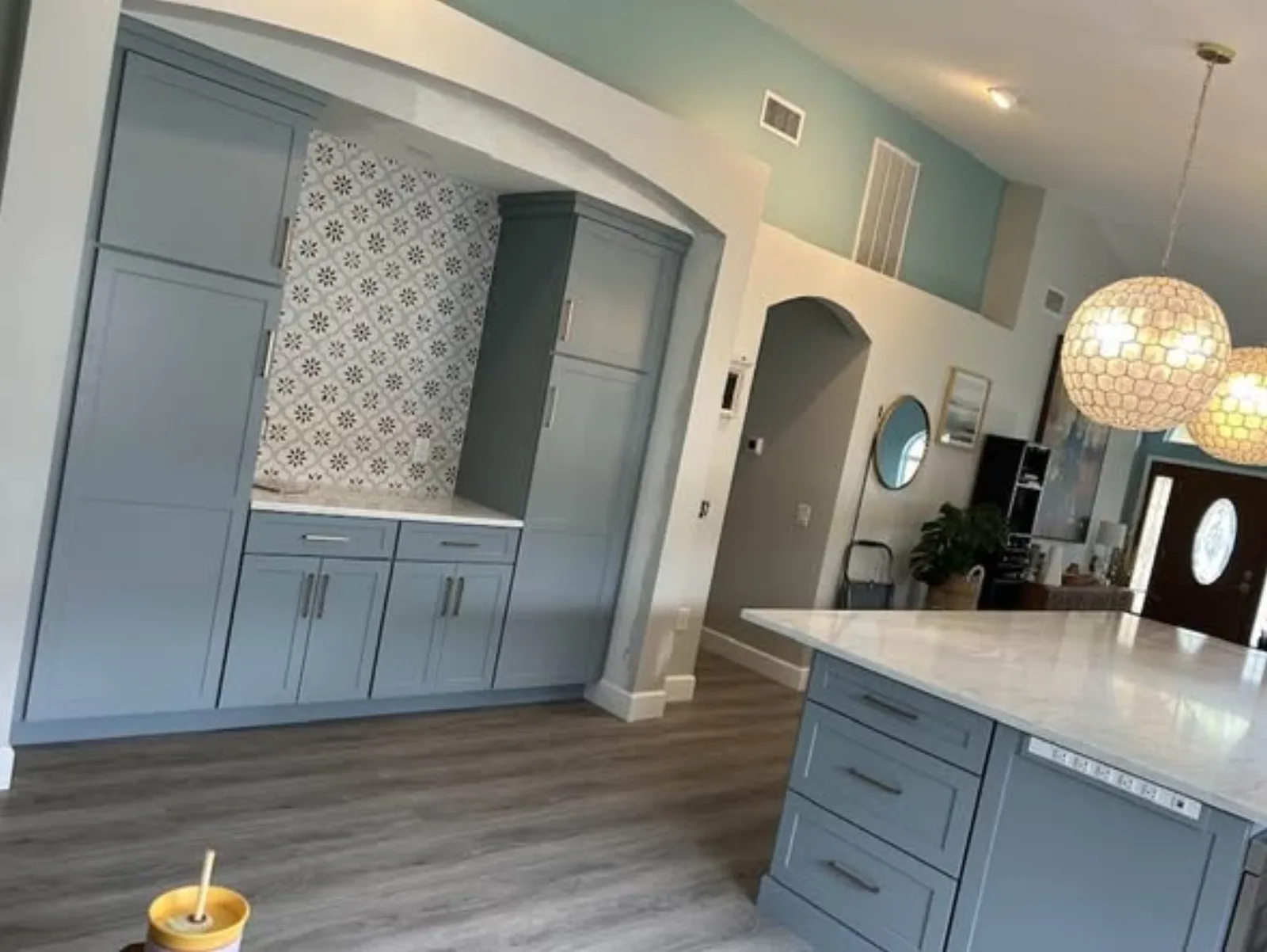 Blue cabinet built-in with arched opening and white pendant lighting